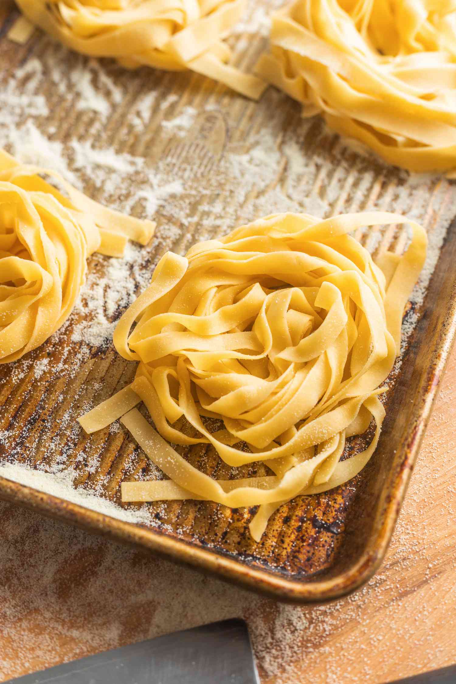 Bundles of Homemade Tagliatelle on a Semolina Dusted Baking Sheet 
