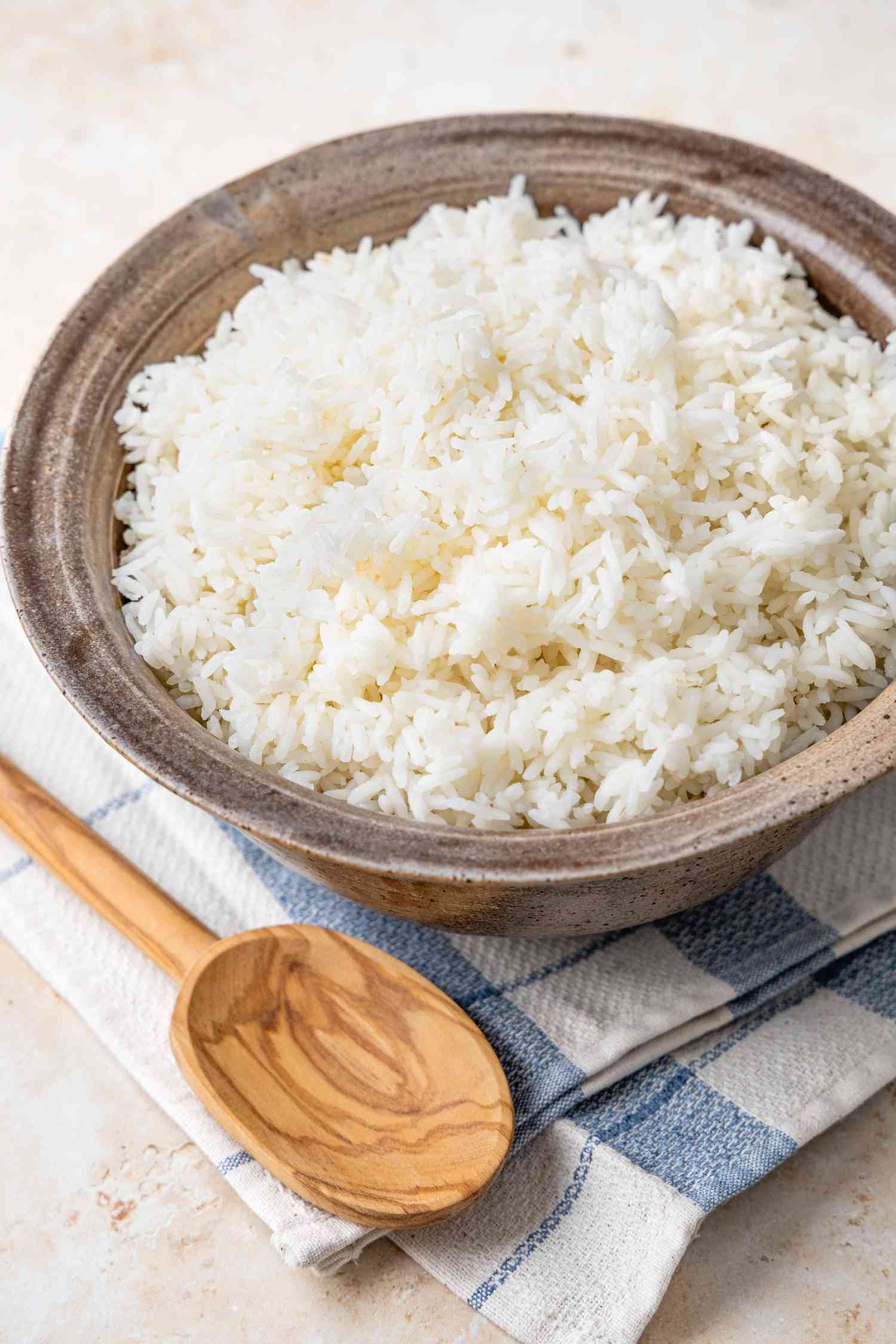 Microwave Rice in a Bowl on a Kitchen Towel with a Wooden Spoon 