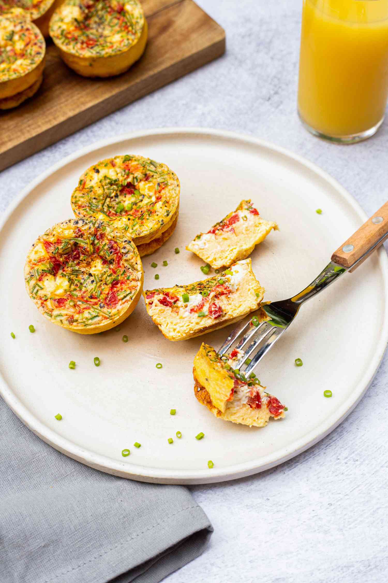 Roasted Red Pepper, Chive, and Chèvre Egg Bites on a Plate with One Cut Into with a Fork