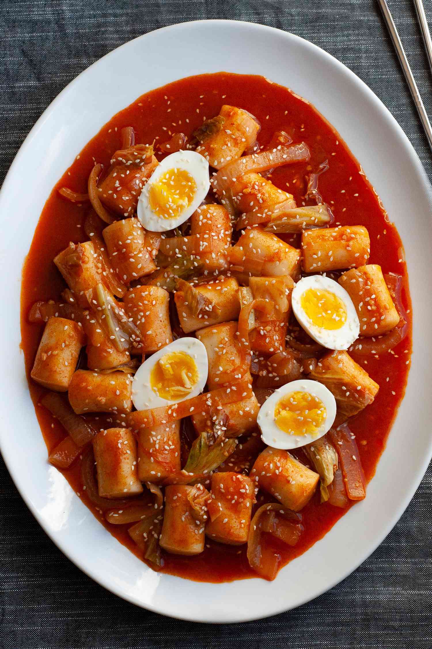 Spicy Korean rice cakes on a white platter.